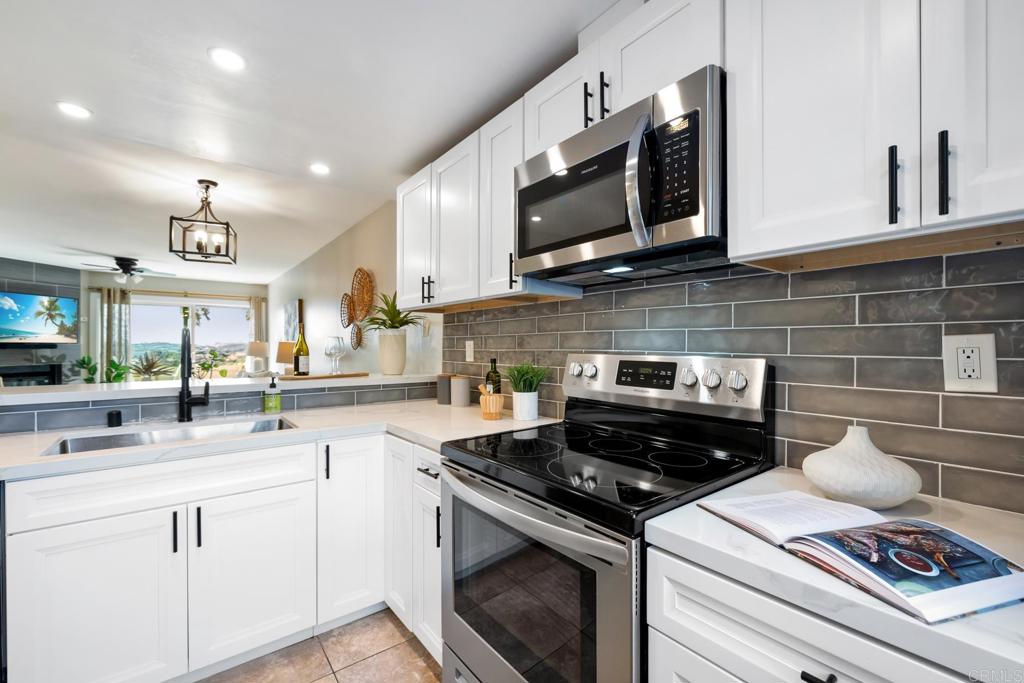 132 South Jayton Lane Encinitas, CA 92024 - Photo 5 of 37 a kitchen with stainless steel appliances a stove a microwave a sink and cabinets