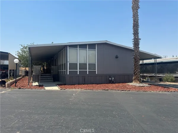a view of a house with a patio and a yard