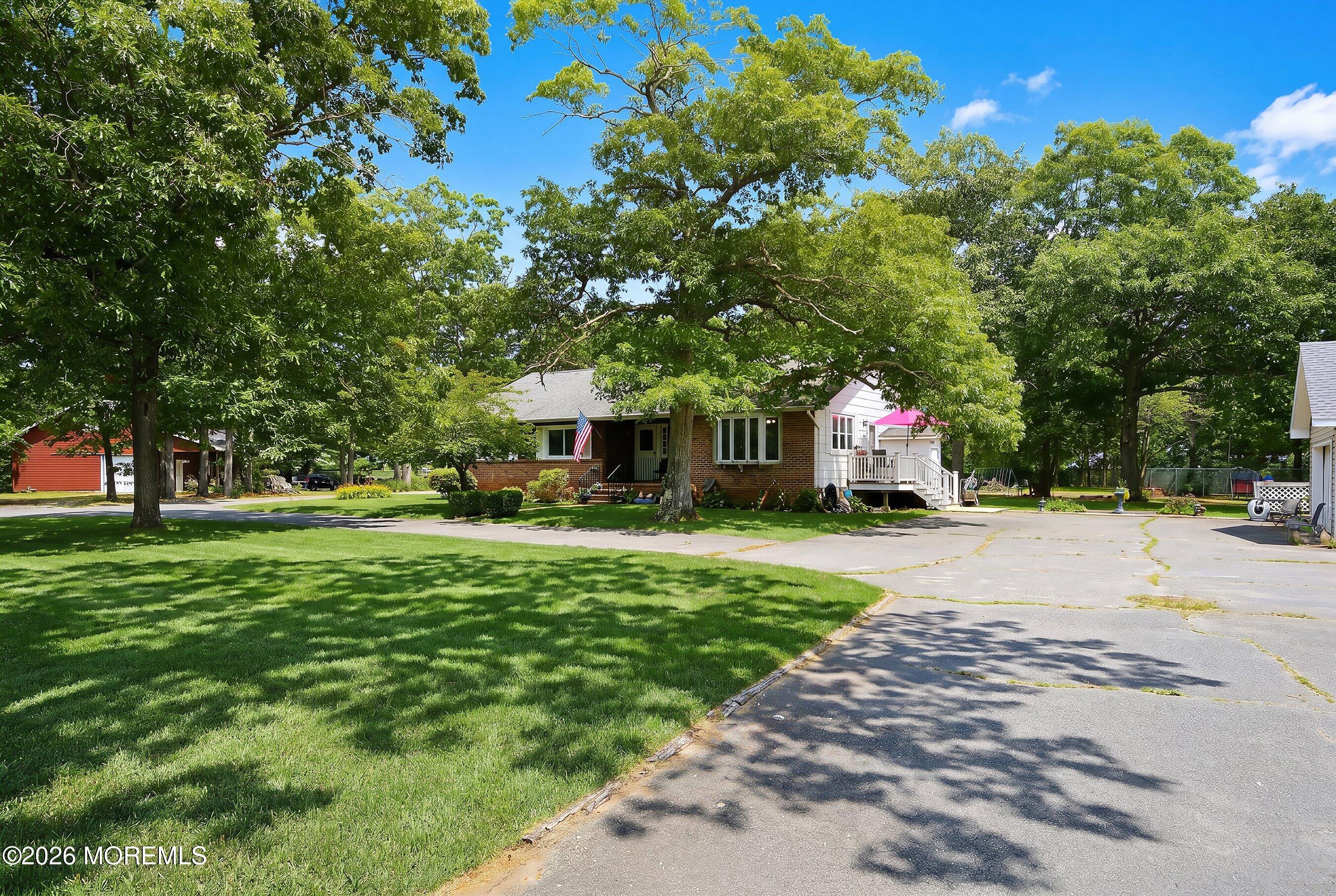 745 Oak Glen Road Howell, NJ 07731 - Photo 3 of 46 a front view of a house with garden and trees
