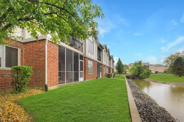 a view of a house with a yard and a large tree