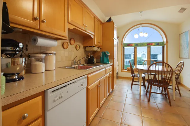 a kitchen with a sink a table and chairs
