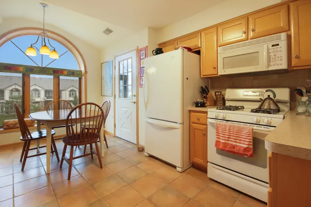 a kitchen with stainless steel appliances granite countertop a stove a refrigerator and a dining table