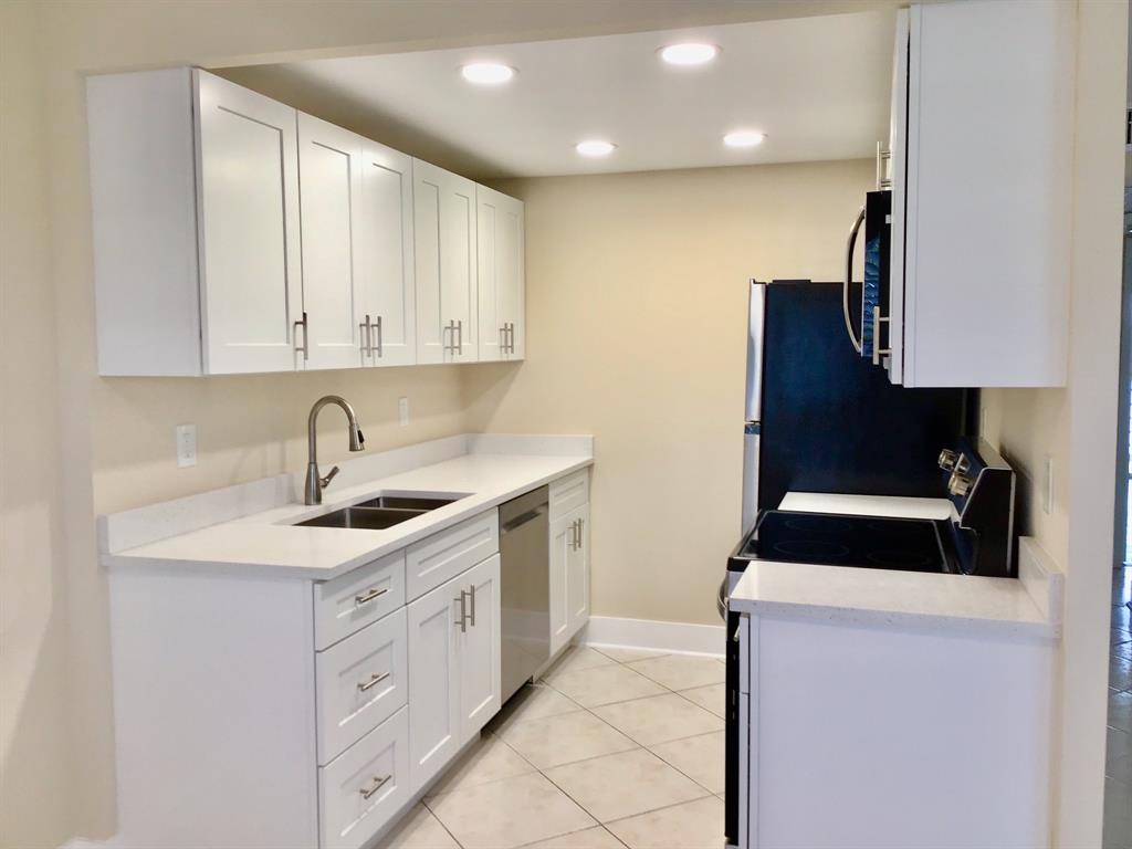 3032 Exeter, Unit 3032 Boca Raton, FL 33434 - Photo 1 of 32 a kitchen with a sink and a stove top oven