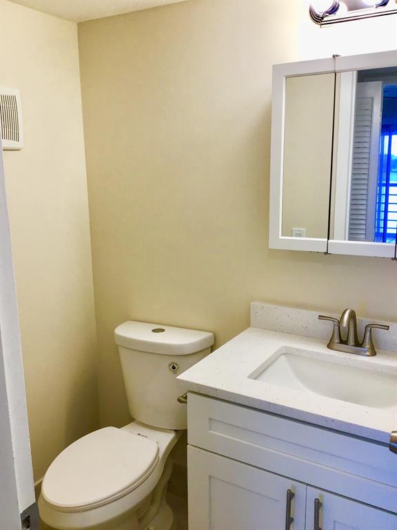 3032 Exeter, Unit 3032 Boca Raton, FL 33434 - Photo 13 of 32 a white toilet sitting next to a bathroom sink