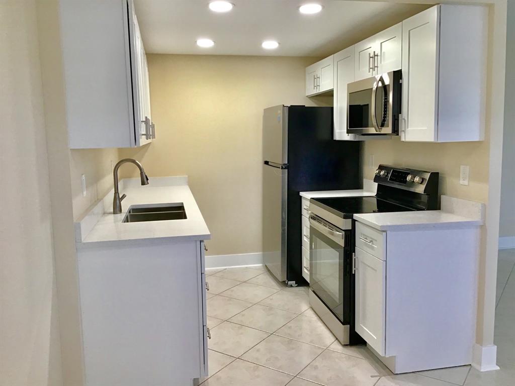3032 Exeter, Unit 3032 Boca Raton, FL 33434 - Photo 2 of 32 a kitchen with stainless steel appliances granite countertop a sink a stove a microwave a counter top space and cabinets