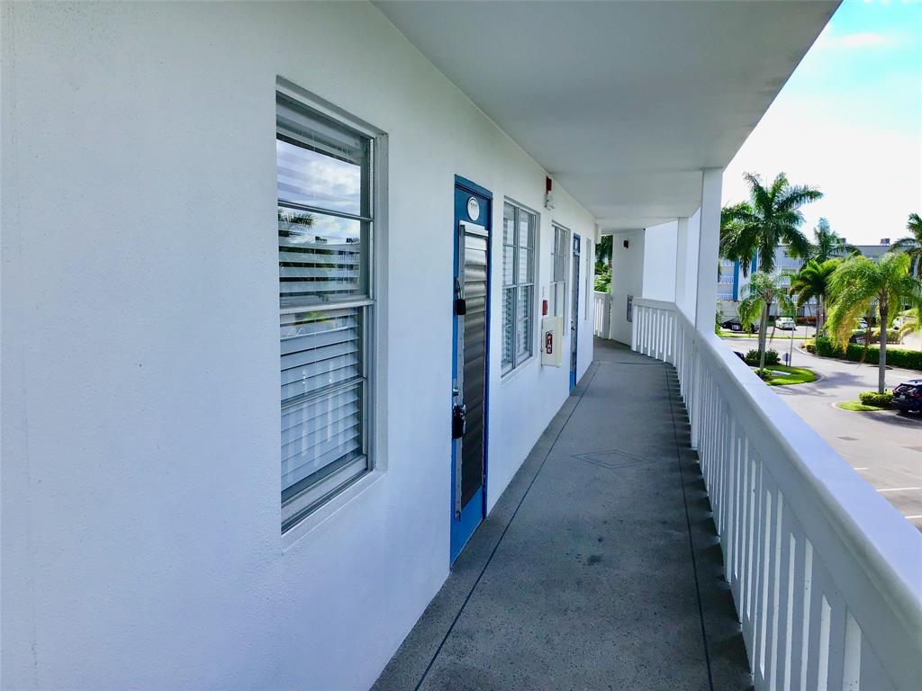 3032 Exeter, Unit 3032 Boca Raton, FL 33434 - Photo 31 of 32 a view of a hallway with wooden floor and stairs