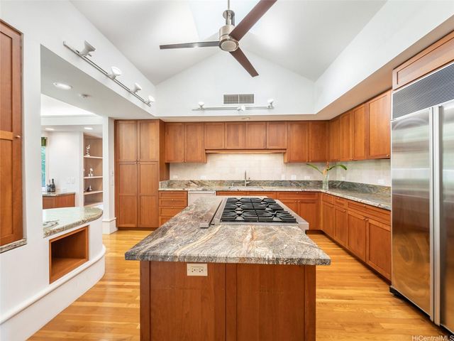 a kitchen with stainless steel appliances granite countertop a stove a sink and a refrigerator