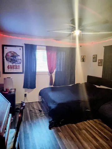 a bedroom with a bed and a dresser next to a window