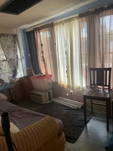 a bedroom with a bed and large windows