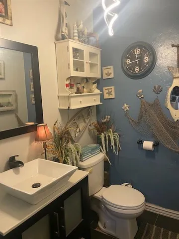 a bathroom with a sink a toilet and mirror