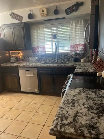 a kitchen with granite countertop a stove a sink and a microwave