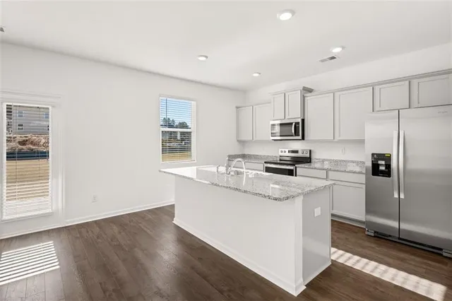 a kitchen with stainless steel appliances granite countertop a stove a sink and a refrigerator