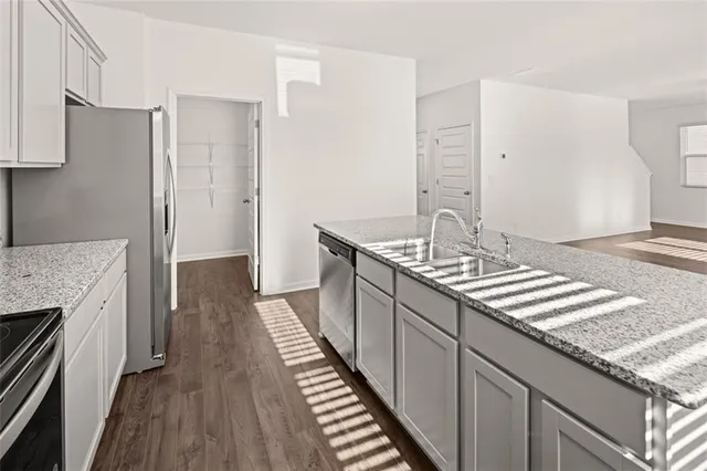 a kitchen with stainless steel appliances granite countertop a sink and a refrigerator