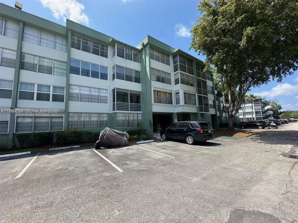 a view of a building with cars parked in front of it
