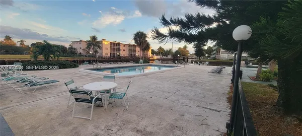 a view of a swimming pool with a patio and fire pit