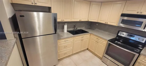 a kitchen with a refrigerator stove and cabinets