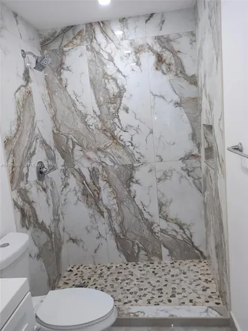 a bathroom with a toilet and a shower