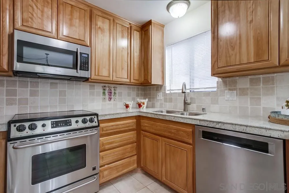 8918 Fletcher Valley Dr. Santee, CA 92071 - Photo 12 of 31 a kitchen with granite countertop stainless steel appliances a stove microwave and sink
