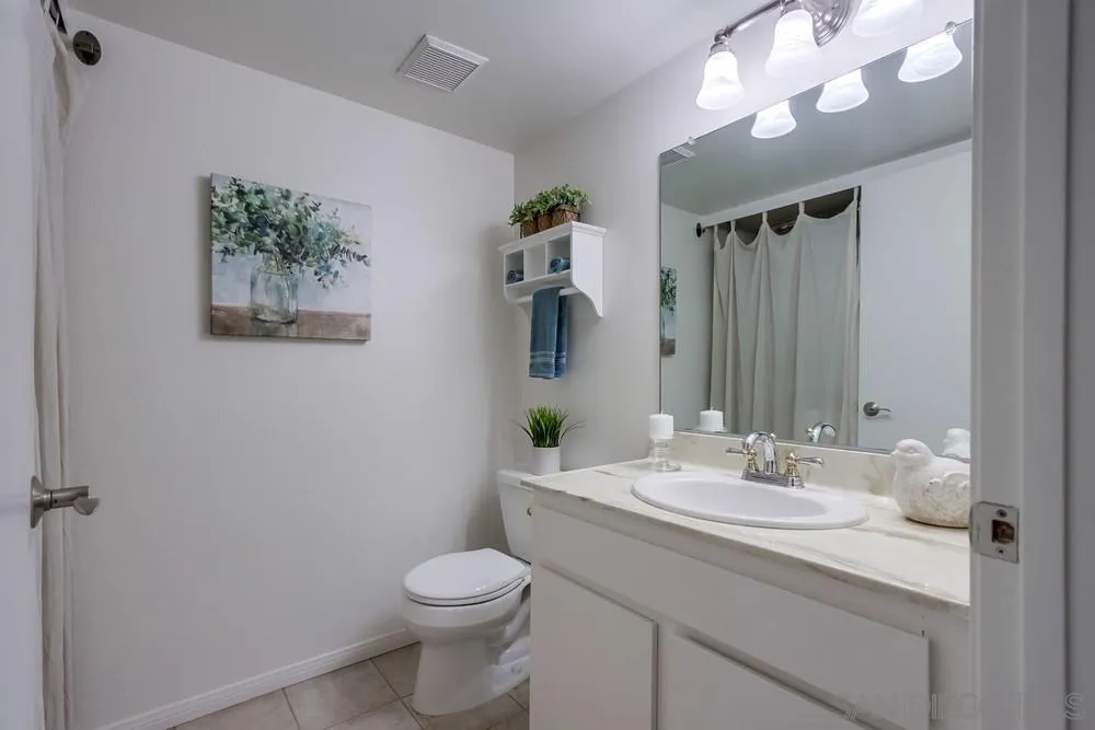 8918 Fletcher Valley Dr. Santee, CA 92071 - Photo 15 of 31 a bathroom with a toilet a sink and mirror