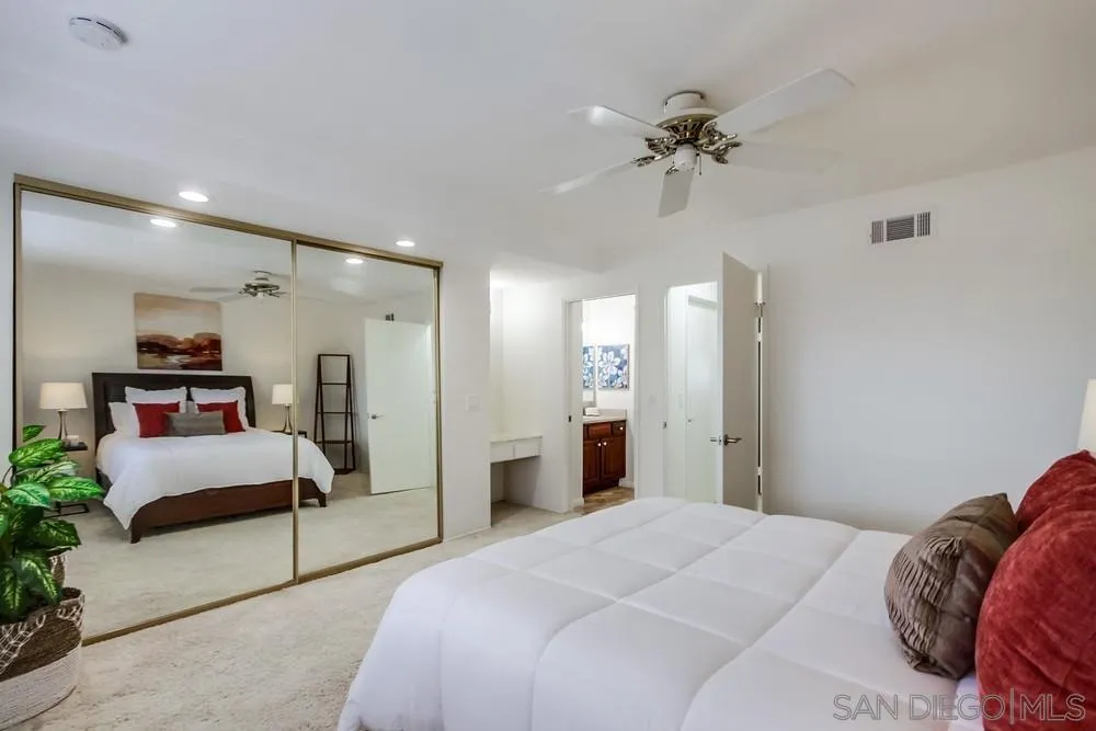 8918 Fletcher Valley Dr. Santee, CA 92071 - Photo 19 of 31 a spacious bedroom with a bed and a chandelier