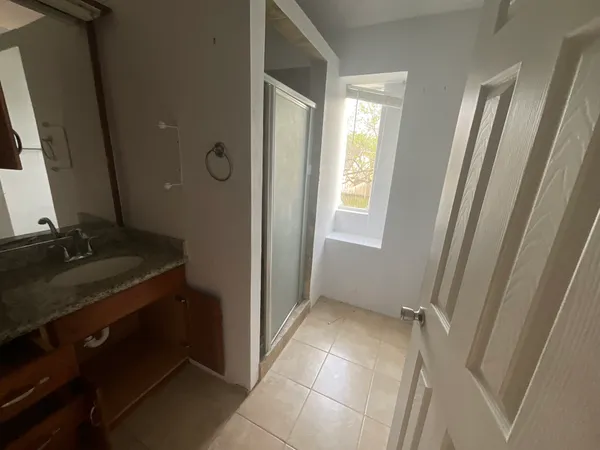 a bathroom with a granite countertop sink and a mirror