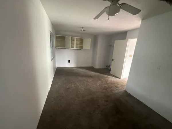 en empty room with windows and cabinet