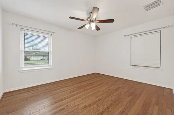 a view of a room with wooden floor and windows
