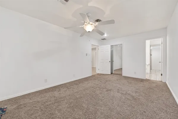 an empty room with a fan and a fan