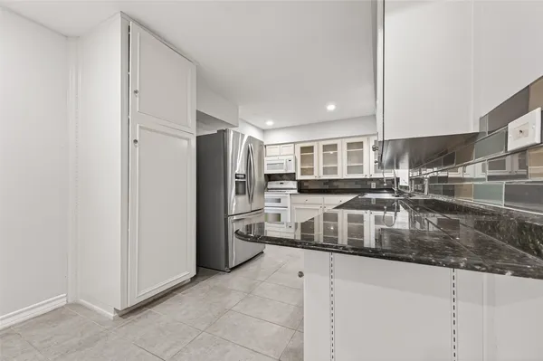 a kitchen with stainless steel appliances granite countertop a refrigerator and a sink