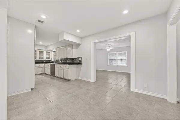 a view of kitchen refrigerator and white cabinets