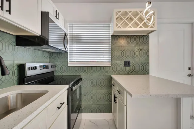 a kitchen with stainless steel appliances granite countertop a sink and a stove