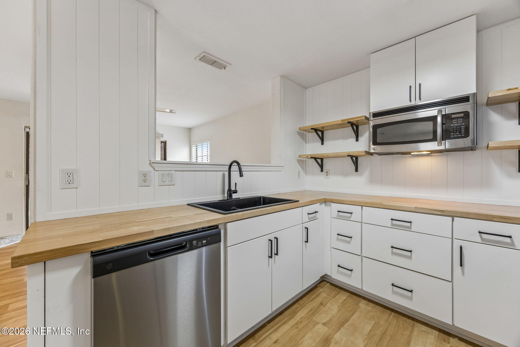 10150 Belle Rive Boulevard, Unit 1109 Jacksonville, FL 32256 - Photo 12 of 55 a kitchen with white cabinets stainless steel appliances and sink