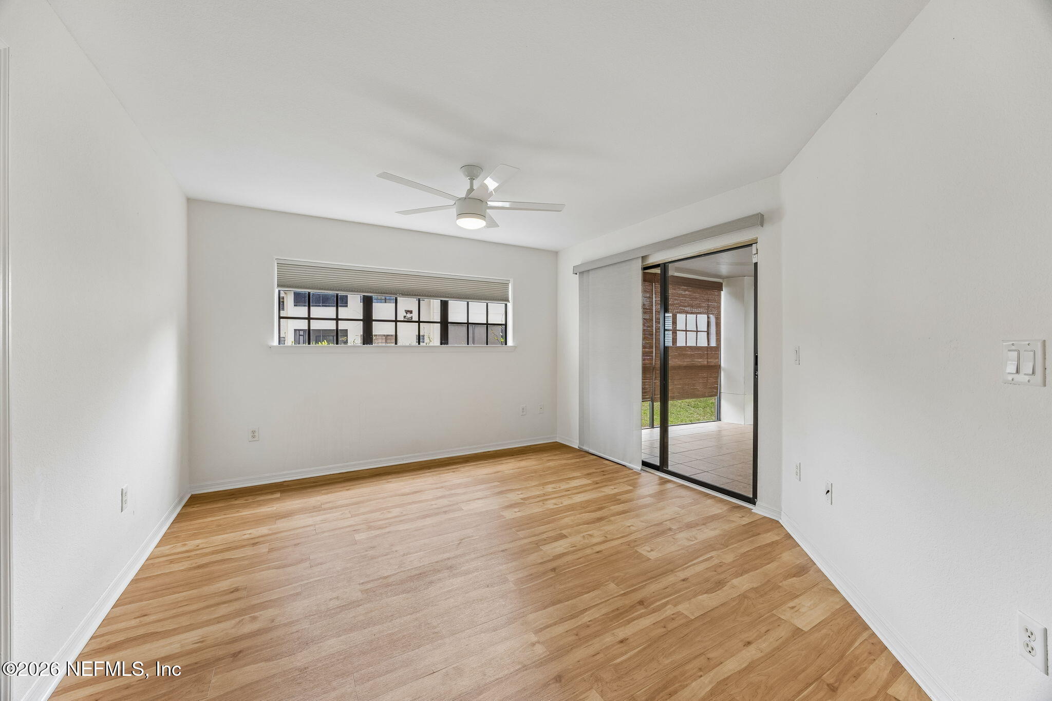 10150 Belle Rive Boulevard, Unit 1109 Jacksonville, FL 32256 - Photo 14 of 55 a view of an empty room with wooden floor and a window