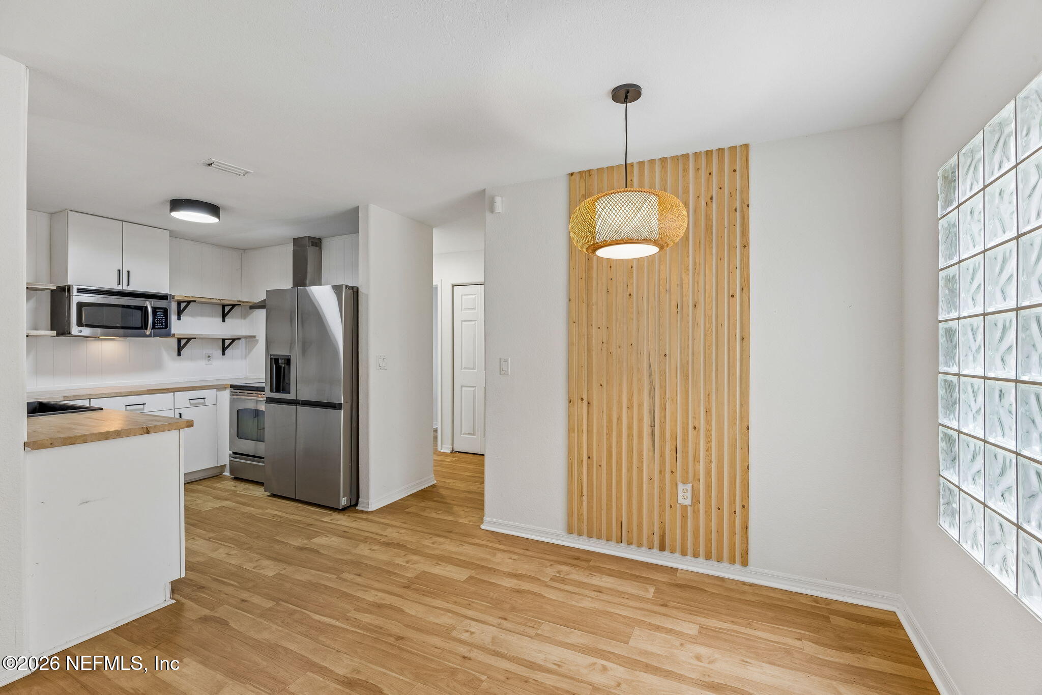 10150 Belle Rive Boulevard, Unit 1109 Jacksonville, FL 32256 - Photo 6 of 55 a view of a kitchen with refrigerator and wooden floor