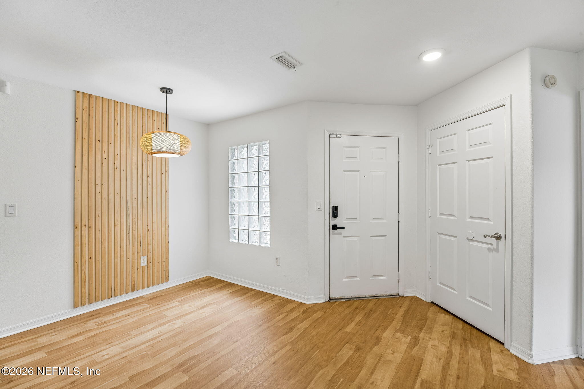 10150 Belle Rive Boulevard, Unit 1109 Jacksonville, FL 32256 - Photo 7 of 55 a view of an empty room with wooden floor and a window