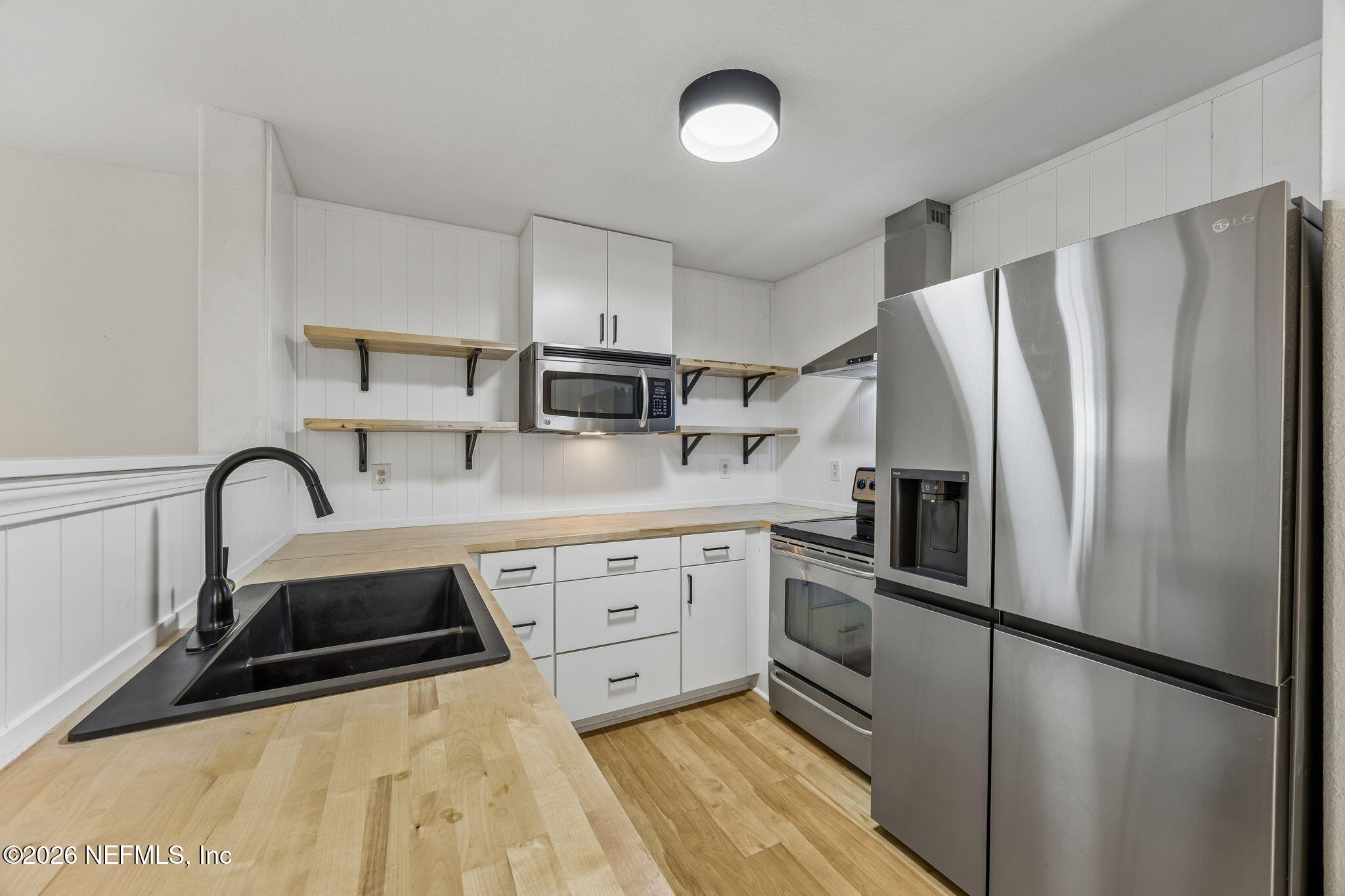 10150 Belle Rive Boulevard, Unit 1109 Jacksonville, FL 32256 - Photo 9 of 55 a kitchen with stainless steel appliances a refrigerator sink and white cabinets