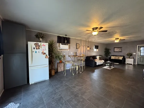 a living room with furniture and a refrigerator