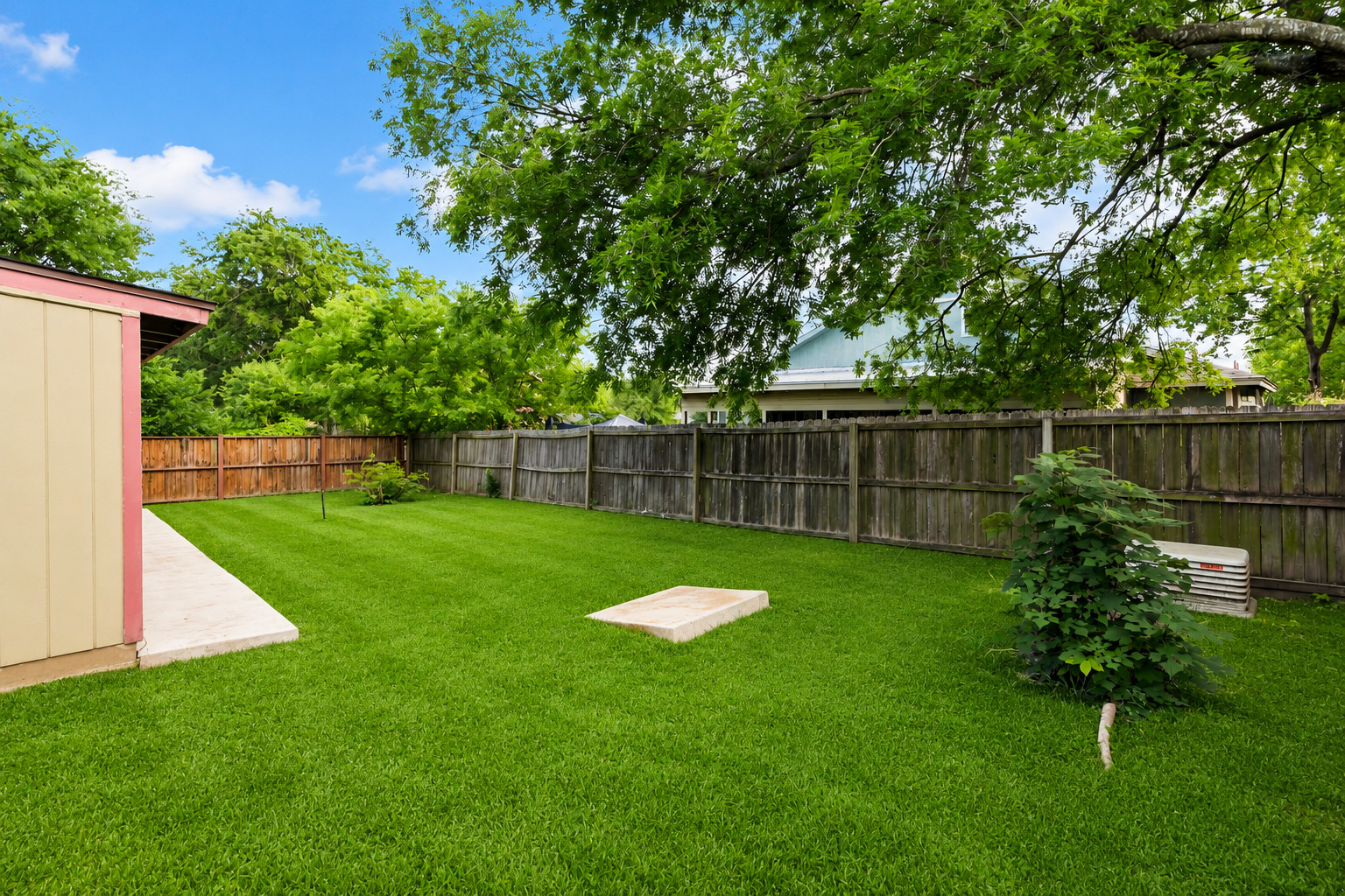 5611 Meadow Crest Austin, TX 78744 - Photo 5 of 29 A generous, green lawn offers ample outdoor space within a fenced yard.