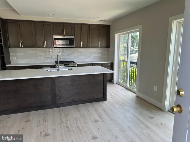a kitchen with wooden floors and wooden cabinets