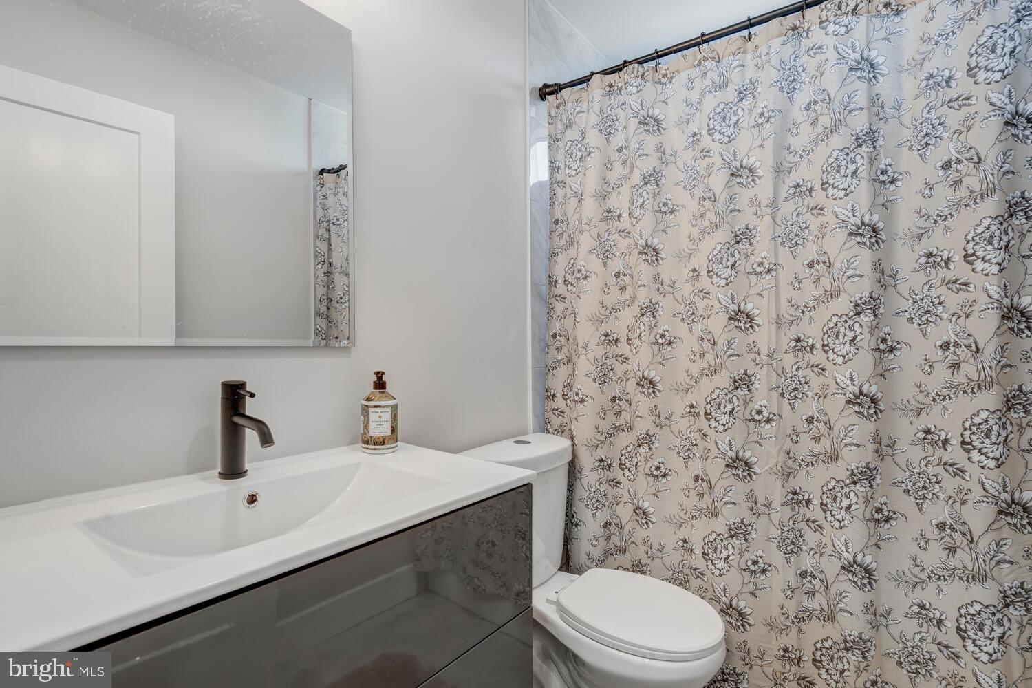 148 Compass Road Manahawkin, NJ 08050 - Photo 33 of 40 a bathroom with a sink a toilet and a mirror
