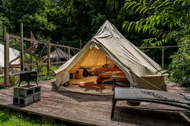 a view of patio with table and chairs potted plants and floor to ceiling window