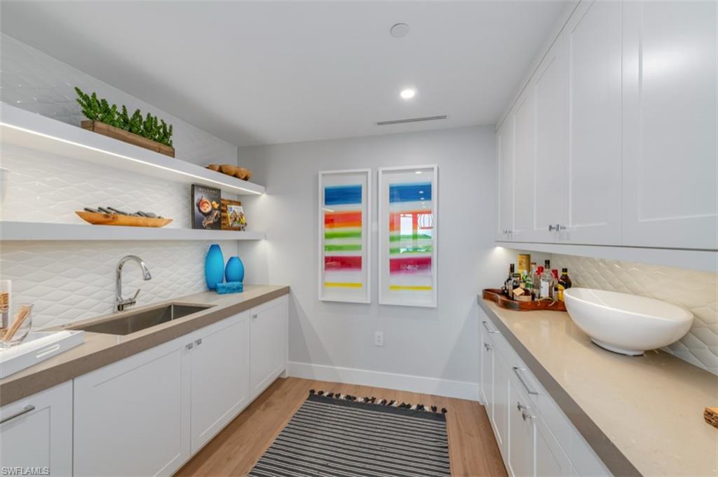 13925 Old Coast Road, Unit 403 Naples, FL 34110 - Photo 12 of 24 Bar featuring backsplash, white cabinets, open shelves, light wood finished floors, and recessed lighting