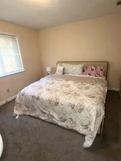 a bed sitting in a bedroom next to a window