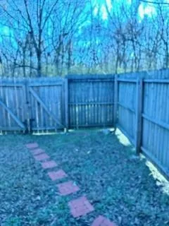 a view of backyard with wooden fence