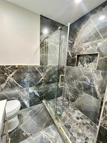 a bathroom with a toilet and a shower