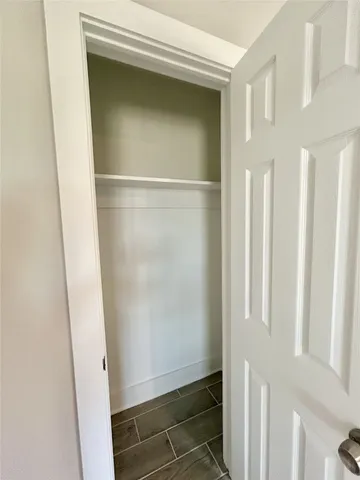 an empty room with wooden floor ceiling fan and windows