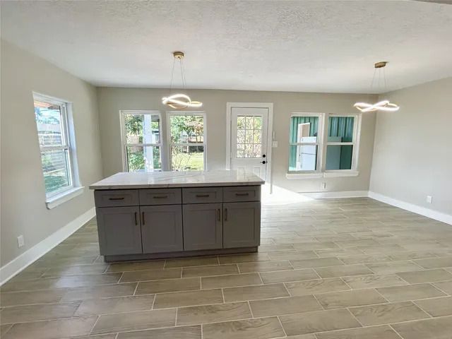 a room with granite countertop a stove and a sink