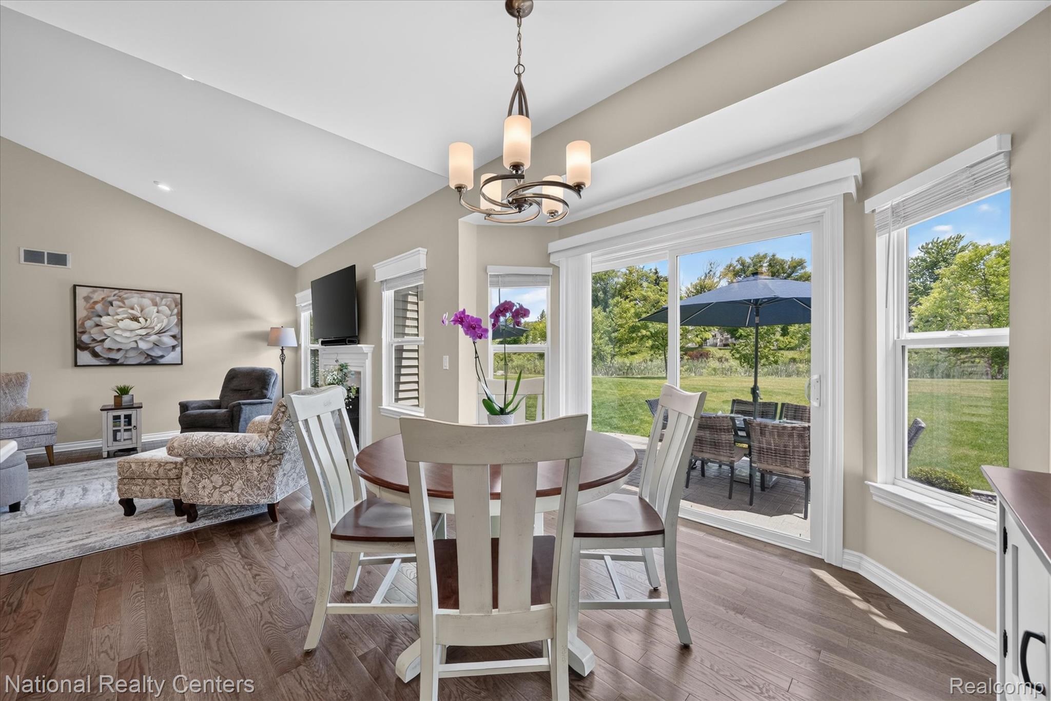740 North Mill Street South Lyon, MI 48178 - Photo 15 of 56 Dining area featuring wood-finish flooring, a contemporary chandelier, and direct access to an outdoor patio through sliding glass doors