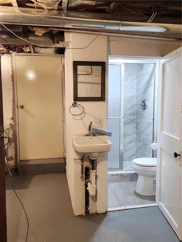 a bathroom with a sink a toilet and shower