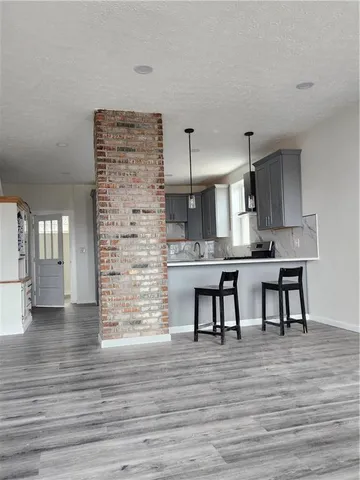 a kitchen with kitchen island stainless steel appliances a dining table chairs and sink